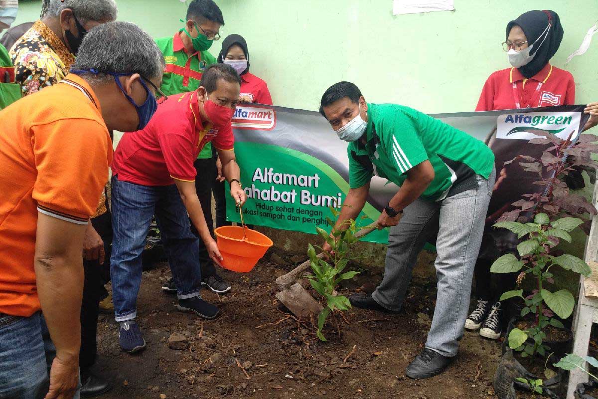 Pembina Kader Lingkungan Hidup Kota Malang bersama Regional Corcom Manager Alfamart menanam pohon. (rhd) - Alfamart Gandeng Kader Lingkungan Kota Malang Tanam Ratusan Pohon di Lowokwaru