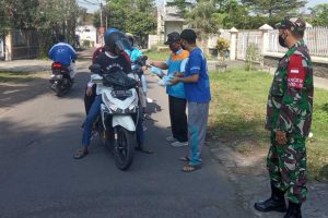 Petugas memberikan masker kepada pengendara motor yang melintas. (ist) - Satgas PPKM Mikro Bandungrejosari Jaring 6 Pengendara Tak Bermasker