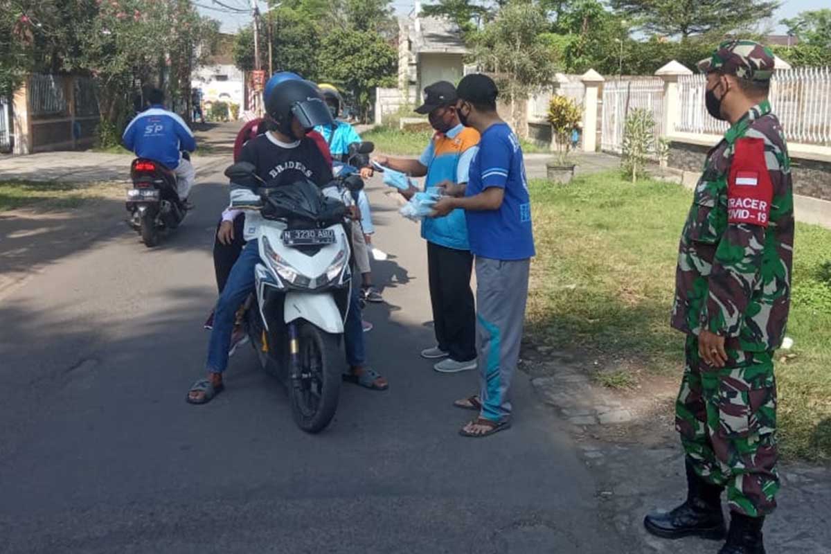 Petugas memberikan masker kepada pengendara motor yang melintas. (ist) - Satgas PPKM Mikro Bandungrejosari Jaring 6 Pengendara Tak Bermasker