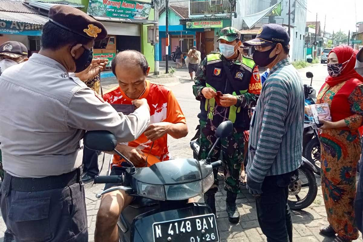 Petugas menjaring pengendara tak pakai masker. (ist) - Satgab Patroli Masker Jaring 10 Pelanggar di Arjosari