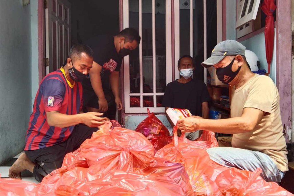 Joshua Nade dibantu keluarga dan teman untuk mengemas paket sembako. (jaz) - Joshua Salurkan Bantuan Paket Sembako Isoman