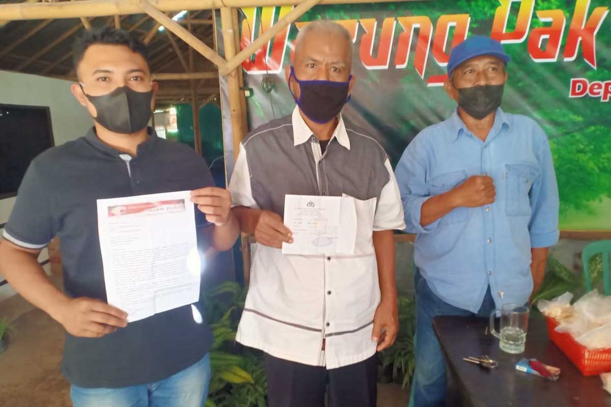 Koordinator Sekber LSM Macan Putih, Suparmin (tengah) menunjukkan surat permohonan penghentian penyidikan yang ditujukan ke Polresta Banyuwangi. (ras) - Sekber LSM Macan Putih Ajukan Pemberhentian Perkara Kelompok Tani Permata