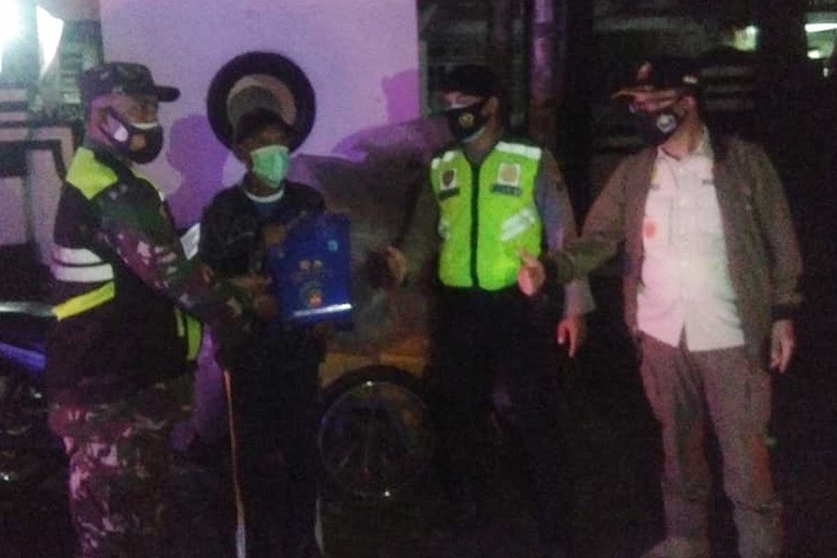Petugas gabungan membagikan sembako saat patroli PPKM Level 4. (ist) - Patroli PPKM Level 4 Kota Malang Berbalut Pembagian Sembako