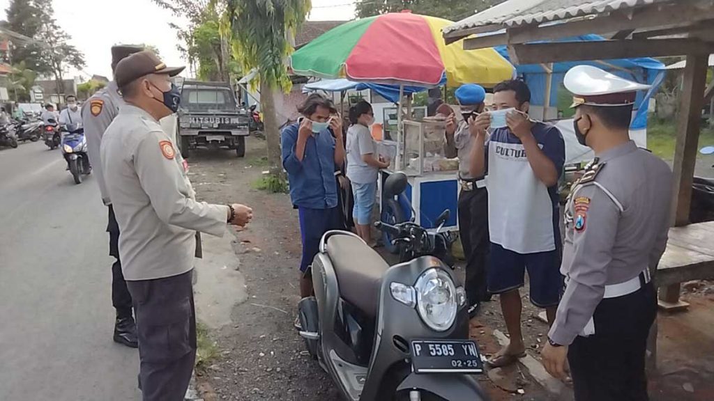 Polsek Muncar saat menggelar operasi yustisi didepan Pujasera, Desa Tembokrejo, Kecamatan Muncar, Senin (12/7/2021) - Polsek Muncar Gelar Operasi Yustisi, 25 Warga Mendapat Teguran