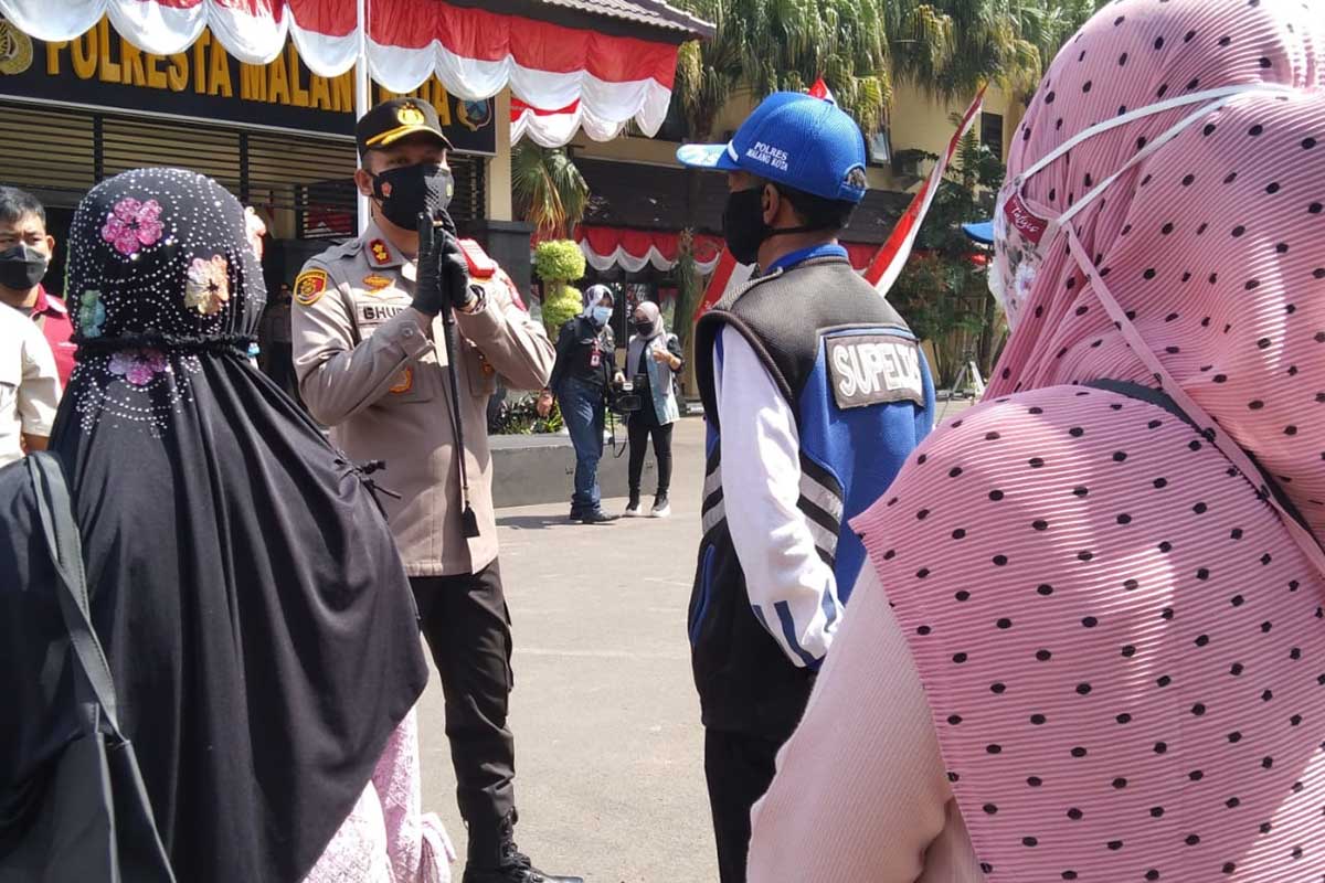 Buher menyerahkan secara simbolis kepada pedagang. (jaz) - Alumni Akpol 2000 Baksos Bagikan 50 Ton Beras dan Sembako