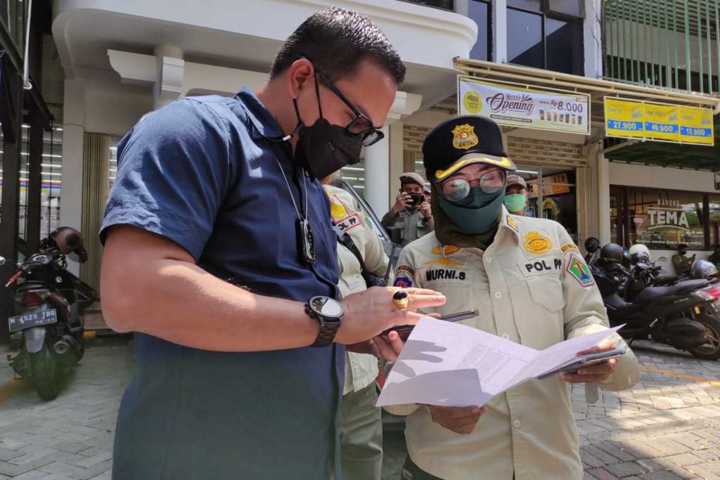 Kepala Bapenda Kota Malang, Dr Handi Priyanto AP MSi, berkoordinasi dengan tim penertiban. (rhd) - Bapenda Kota Malang Tertibkan Reklame Liar dan Nakal