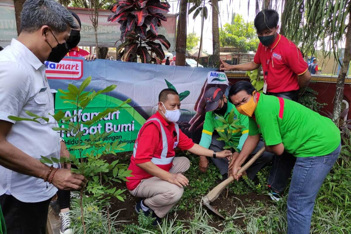 Pembina Kader Lingkungan Hidup Kota Malang bersama Regional Corcom Manager Alfamart, menanam salah satu jenis pohon. (rhd) - Alfamart - Kader Lingkungan Kota Malang Tanam 50 Pohon di Arjowinangun