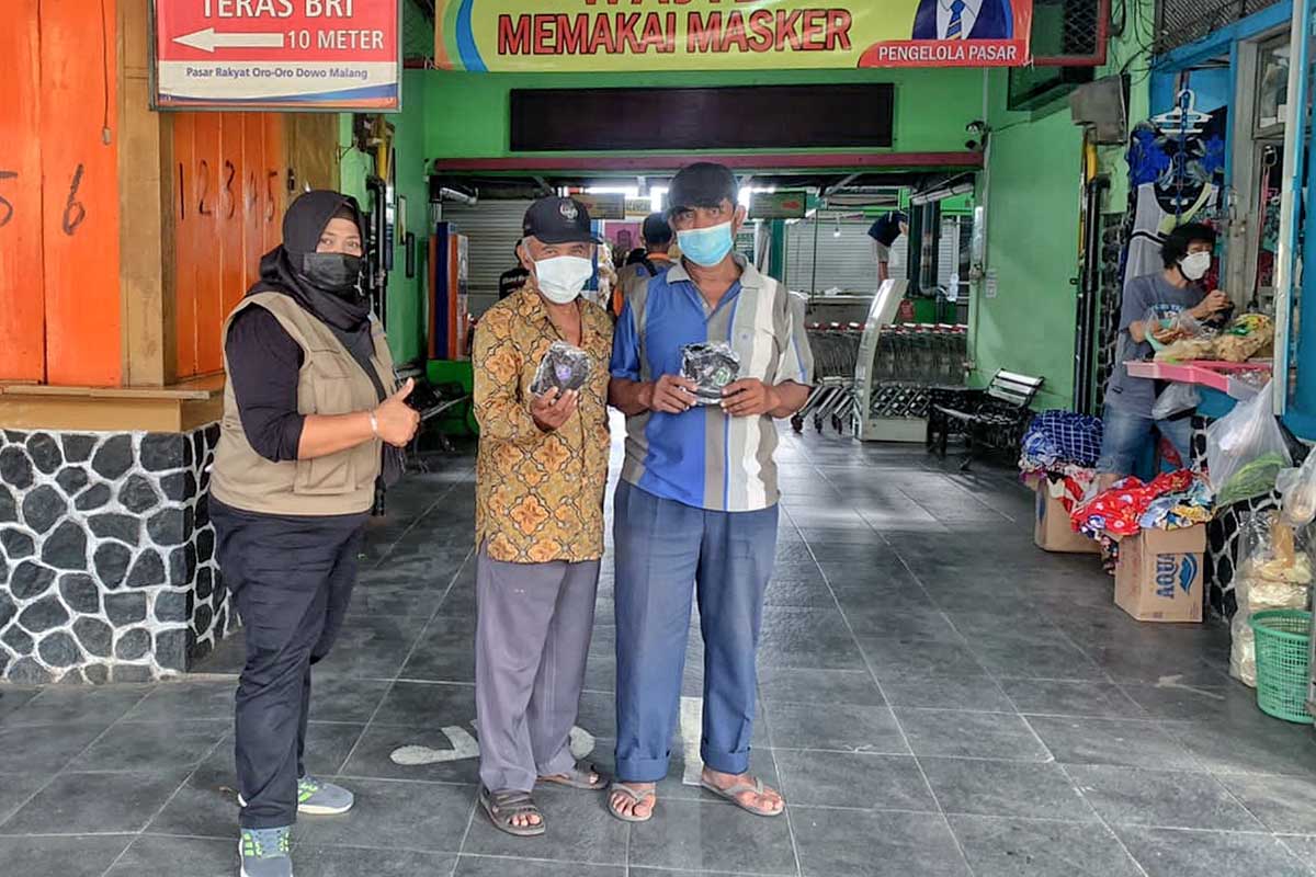 BPBD Kota Malang membagikan masker kepada pedagang pasar. (jaz) - BPBD Kota Malang Bagikan Ratusan Ribu Masker BNPB
