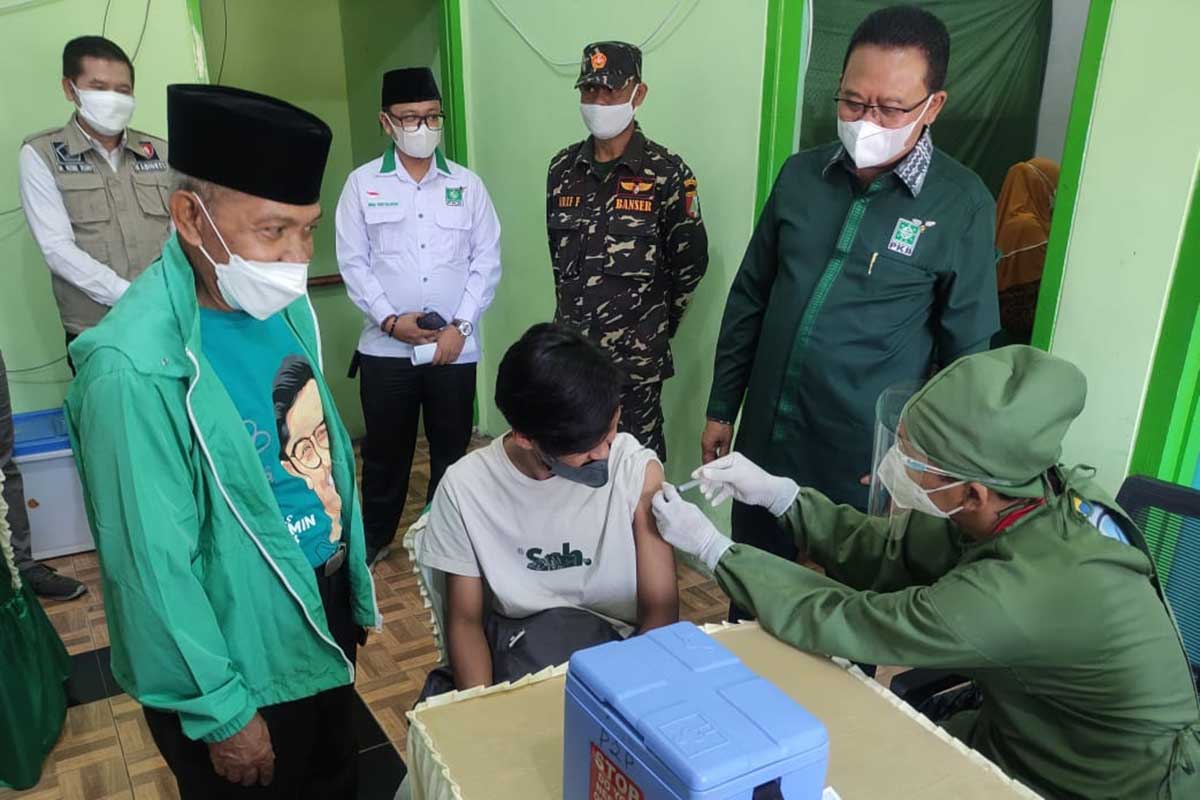 Gus Ali Ahmad menyemangati salah satu penerima vaksin agar tidak takut jarum suntik. (rhd) - Gus Ali Ahmad Gelontorkan 8.000 Dosis Vaksin Dukung Herd Immunity Malang Raya
