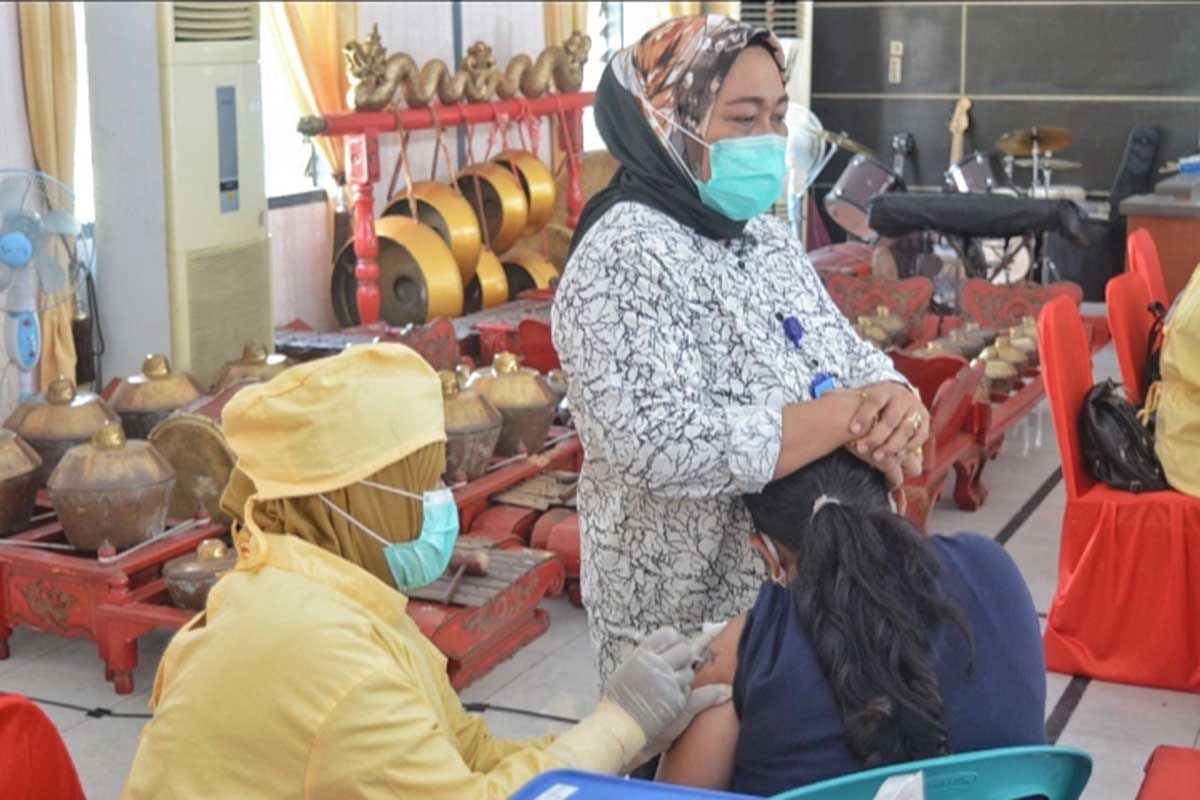 Kalapas Perempuan Kelas II A, Tri Ana Ariyanti, mendampingi salah satu warga binaan yang divaksin. (ist) - Lapas Perempuan 50 Persen Sudah Tervaksin Dosis Dua