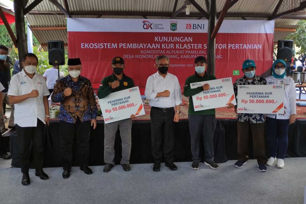 Penyerahan simbolis KUR kepada perwakilan kelompok tani. (rhd) - OJK Dukung KUR Pertanian Alpukat Pameling di Kabupaten Malang