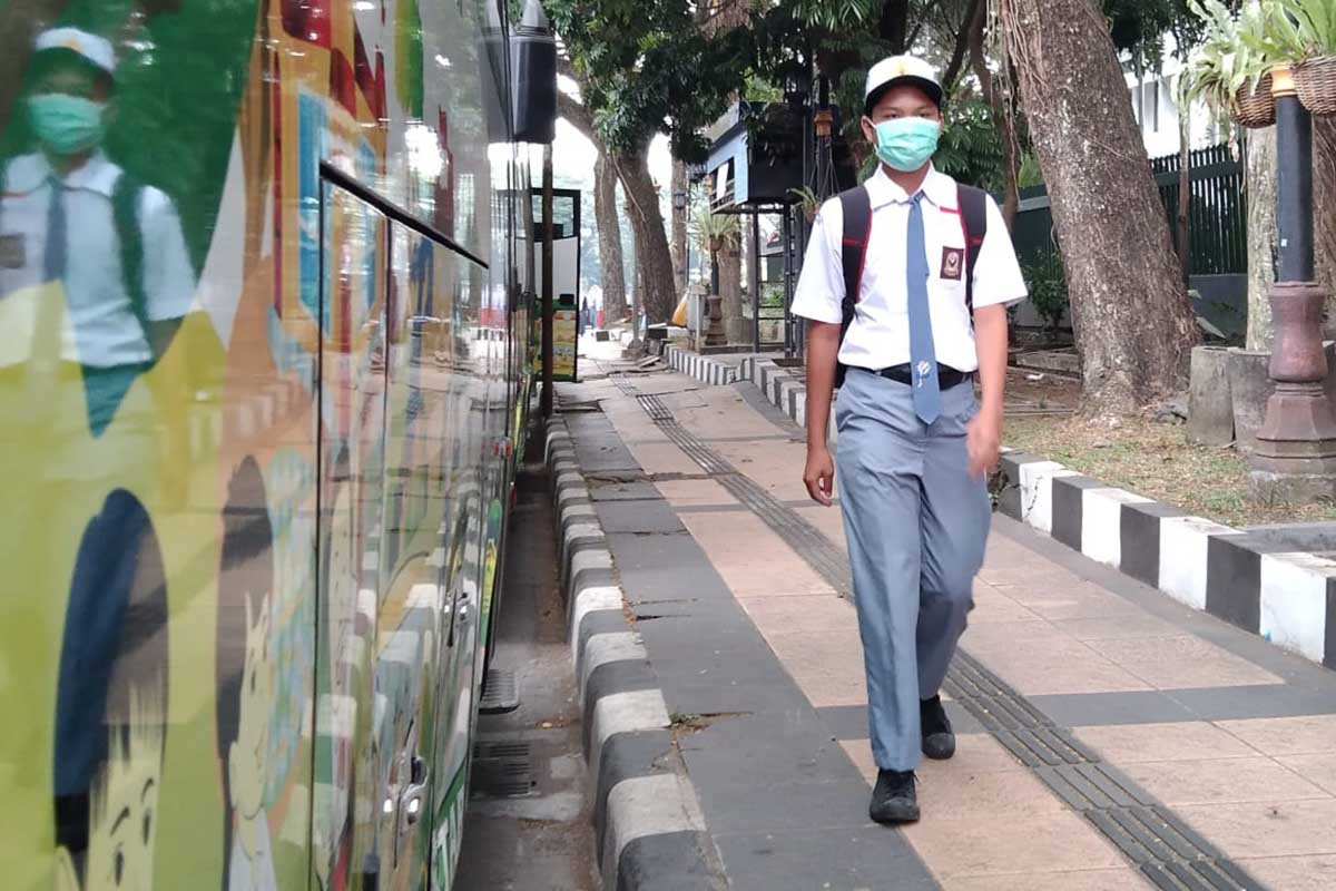 Salah satu siswa melintasi trotoar di Kota Malang. (jaz) - PTM Hari Pertama, Siswa Diperkenankan Tak Berseragam Hingga Bersepatu Seadanya