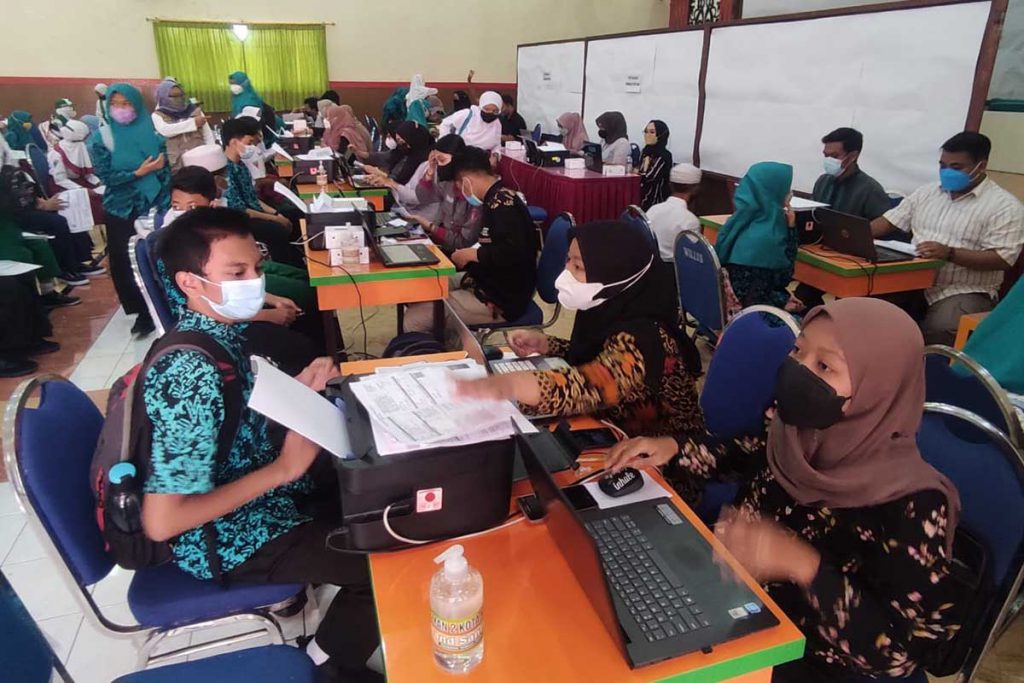 Siswa MTsN 1 berbaur dengan siswa madrasah lainnya menjalani skrining. (rhd) - 2000 Siswa Madrasah se-Kota Malang Divaksin Sinovac - MTsN 1 Kota Malang Hampir 100 Persen Herd Immunity