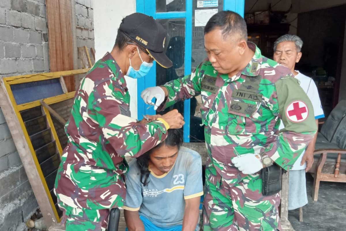 Tim medis Satgas TMMD 112 mengobati luka di kepala Yatmo. (ist) - Tim Medis Satgas TMMD 112 Tanggap Kebutuhan Darurat Warga