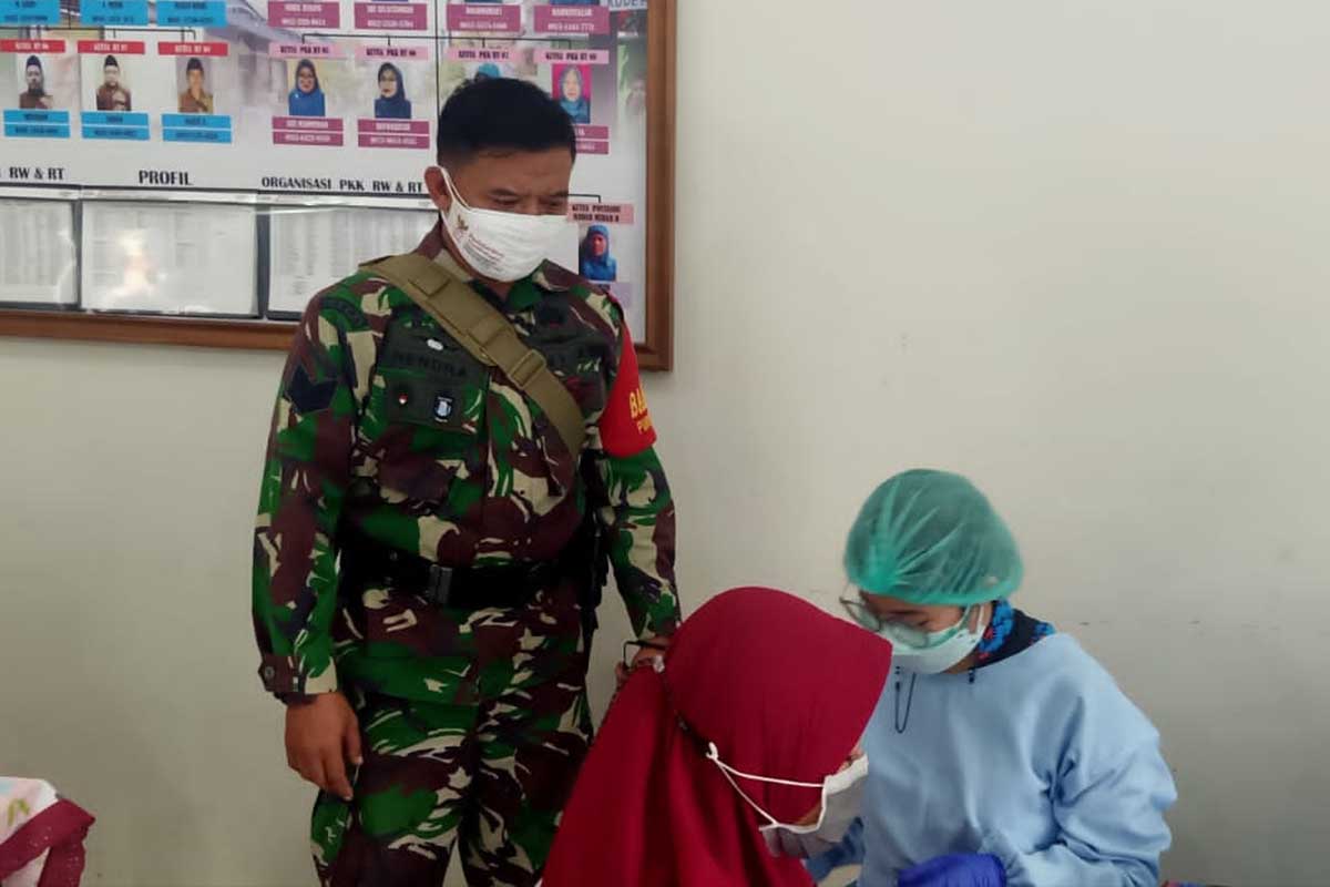 Babinsa Purwantoro ikut mengawasi jalannya vaksinasi. (ist) - Warga Empat RW Purwantoro Serbu Vaksin di Puskesmas Cisadea