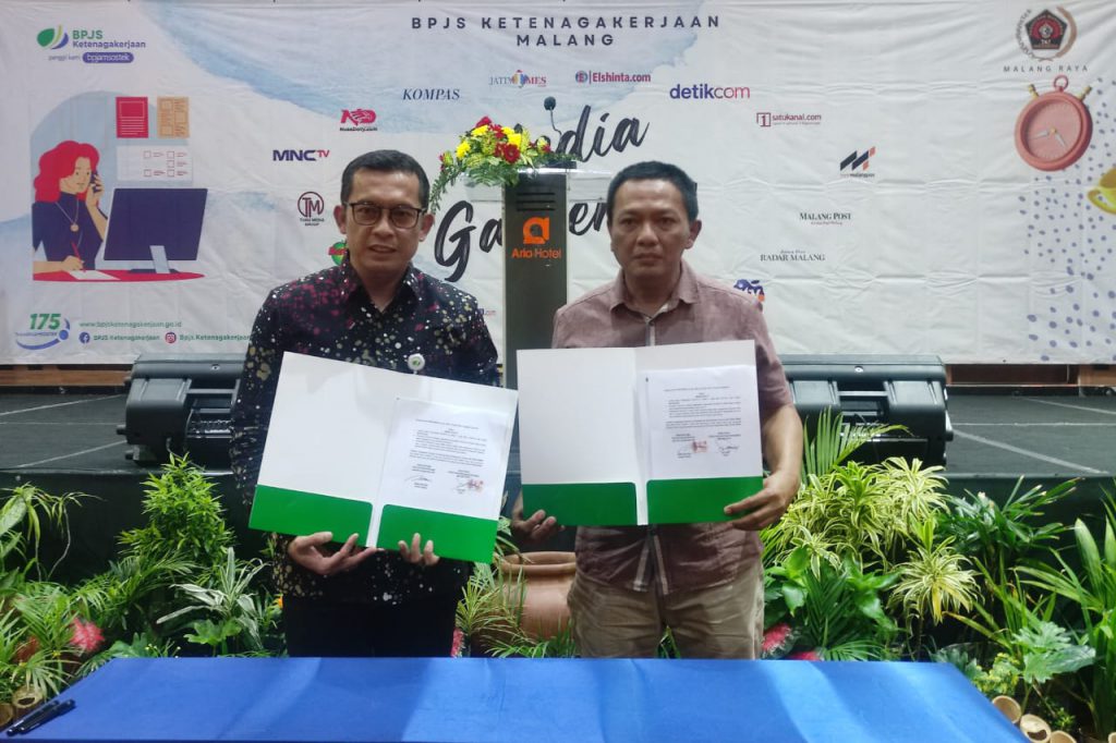 Kepala BPJS Ketenagakerjaan Cabang Malang Raya, Imam Santoso, dan Ketua PWI Malang Raya, Cahyono, menunjukkan MoU.