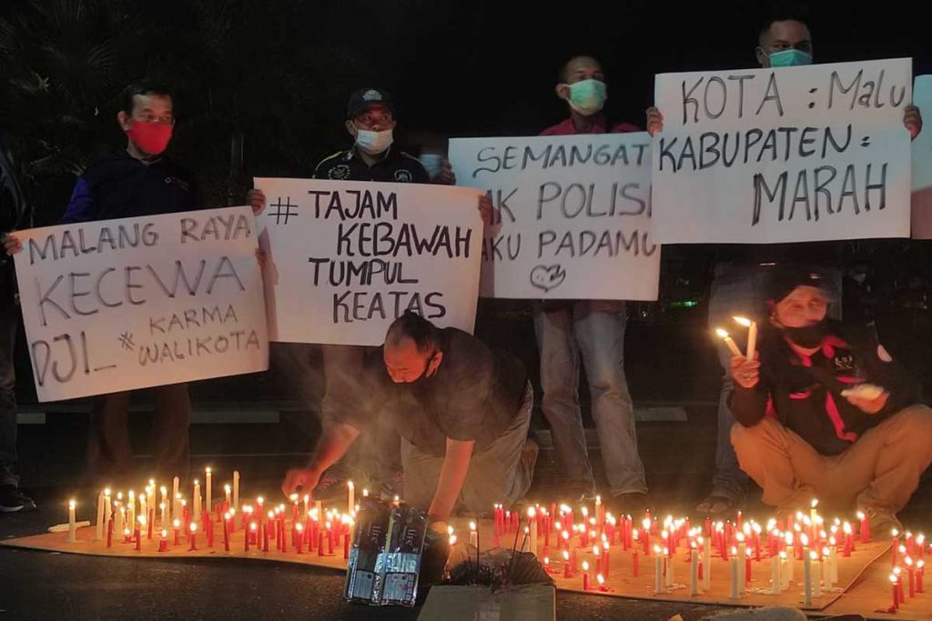Massa bentangkan beberapa tulisan aksi. (rhd) - Seribu Lilin Dukung Polda Jatim Tegakkan Hukum Pelanggaran PPKM di Kondang Merak