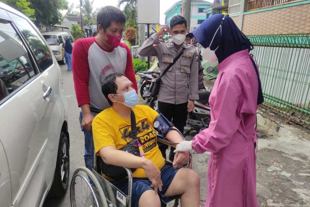 Petugas medis rela turun melayani skrining drive thru bagi peserta pasca kecelakaan. (rhd) - PWI Malang Raya, IBU dan Polresta Makota Sukses Vaksin Ribuan Warga