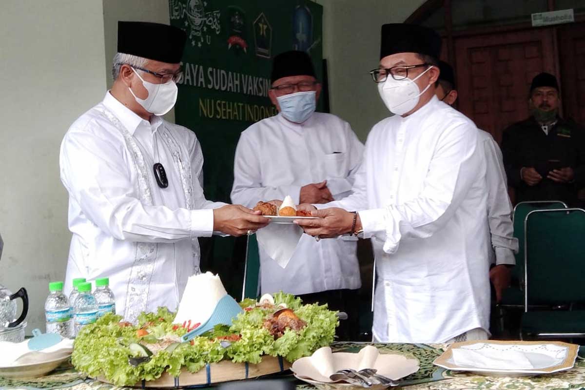 Walikota Malang menerima potongan tumpeng selepas Apel Hari Santri. (jaz) - Peringati Hari Santri, Pemkot Malang Komitmen Penguatan Ekonomi Ponpes