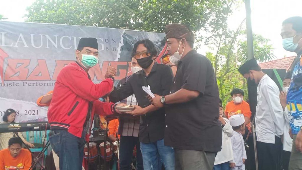 Anggota DPRD Banyuwangi, Heksa Sudarmaji menyerahkan nasi potong tumpeng kepada Endras Puji Yuwono. (Foto: Aras Sugiarto, SERU.co.id) - Sanggar Seni Ilalang Wadah Pelaku Dan Pekerja Seni Khas Banyuwangian