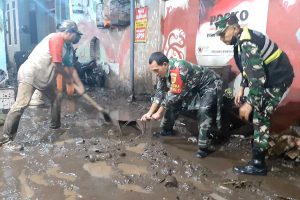 Anggota TNI turun lapangan membersihkan sisa-sisa lumpur banjir bandang. (ist) - Asesmen Sementara Kodim 0833, 10 Lokasi Kota Malang Terdampak Banjir - Dandim 0833 : Babinsa Turun Lapangan Tangani Kelurahan Terdampak Banjir