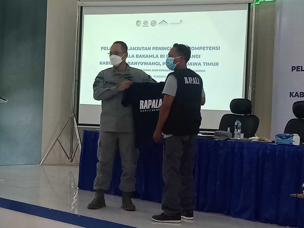 Kepala kantor Kamla Zona Maritim Tengah, Laksma Bakamla Hanarko Djodi Pamungkas saat menyerahkan baju kepada peserta pelatihan lanjutan Peningkatan Kompetisi Rapala Bakamla RI Banyuwangi. (Foto: Gatut Imawan, SERU.co.id) - Tingkatkan Kompetensi Anggota, Rapala Bakamla RI Banyuwangi Dalami SAR