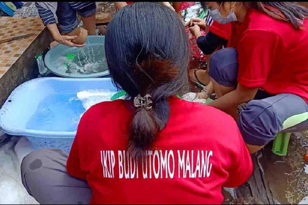 Mahasiswi wanita mencuci peralatan rumah tangga. (ist) - IBU Malang Peduli Sosial, Terjun Kerja Bakti Bersihkan Sampah Banjir