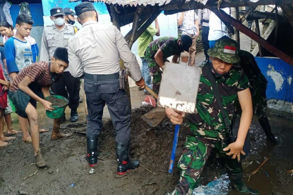 TNI-POLRI bahu membahu bersama warga setempat membersihkan lumpur banjir bandang. (ist) - Asesmen Sementara Kodim 0833, 10 Lokasi Kota Malang Terdampak Banjir - Dandim 0833 : Babinsa Turun Lapangan Tangani Kelurahan Terdampak Banjir