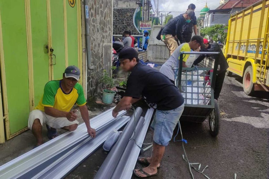 Warga dan relawan gotong royong membawa material bangunan yang dibutuhkan. (rhd) - UMM Berbagi Untuk Negeri Bantu Korban Banjir Jodipan
