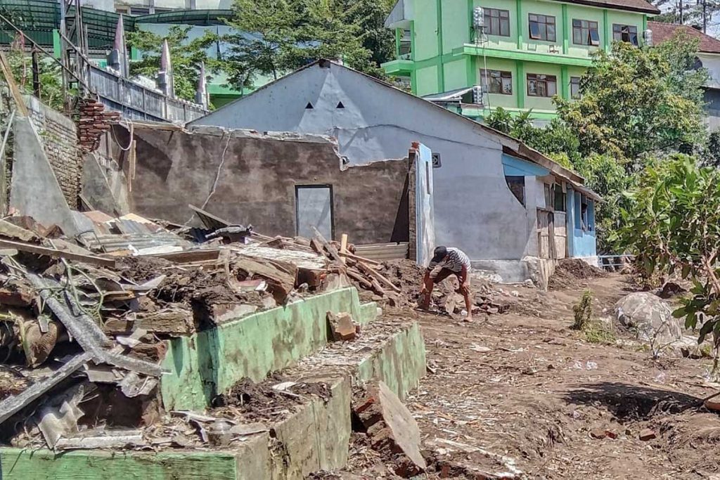 Warga sedang membersihkan rumah yang telah hanyut diterjang banjir kiriman dari Kota Batu. (jaz) - Tanggap Bencana, Tagana Usulkan Pusat Emergency di Malang