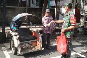 Anggota Koramil membagikan nasi bungkus kepada tukang becak. (ist) - Peringati Hari Juang Kartika, Kodim 0833 Kota Malang Bagikan Nasi Bungkus