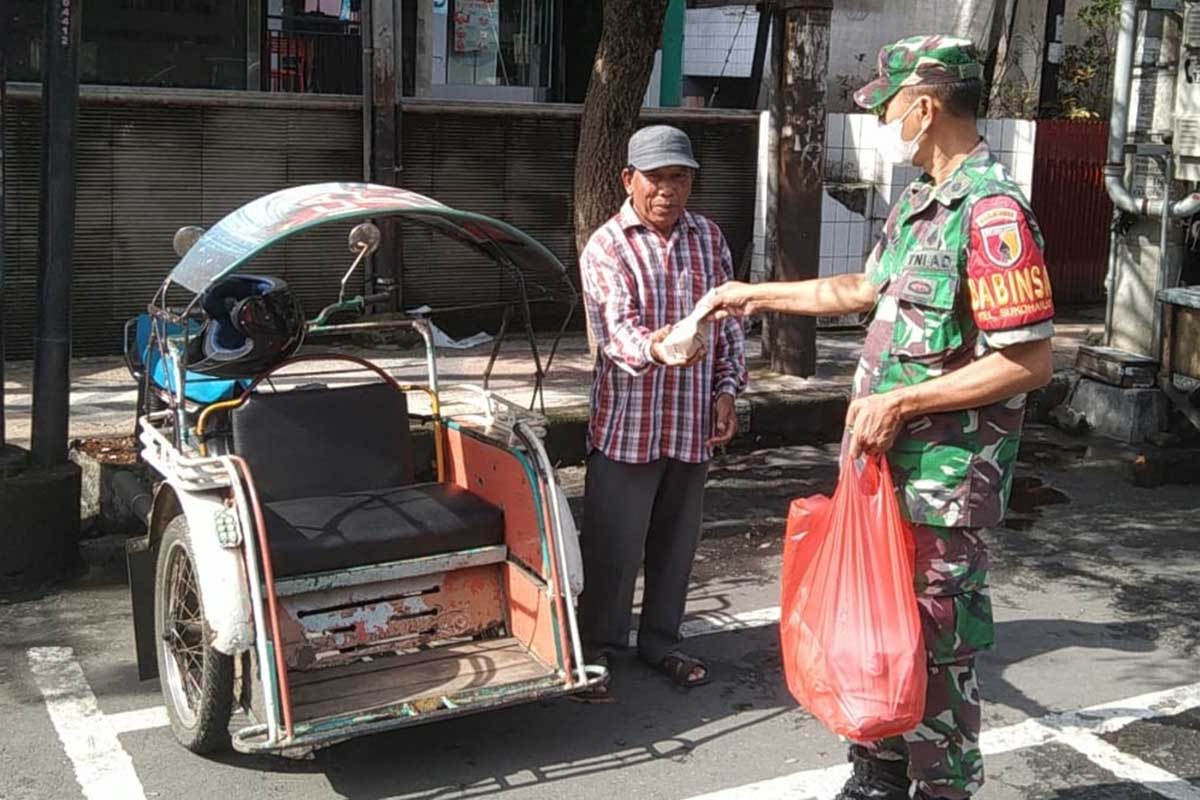 Anggota Koramil membagikan nasi bungkus kepada tukang becak. (ist) - Peringati Hari Juang Kartika, Kodim 0833 Kota Malang Bagikan Nasi Bungkus