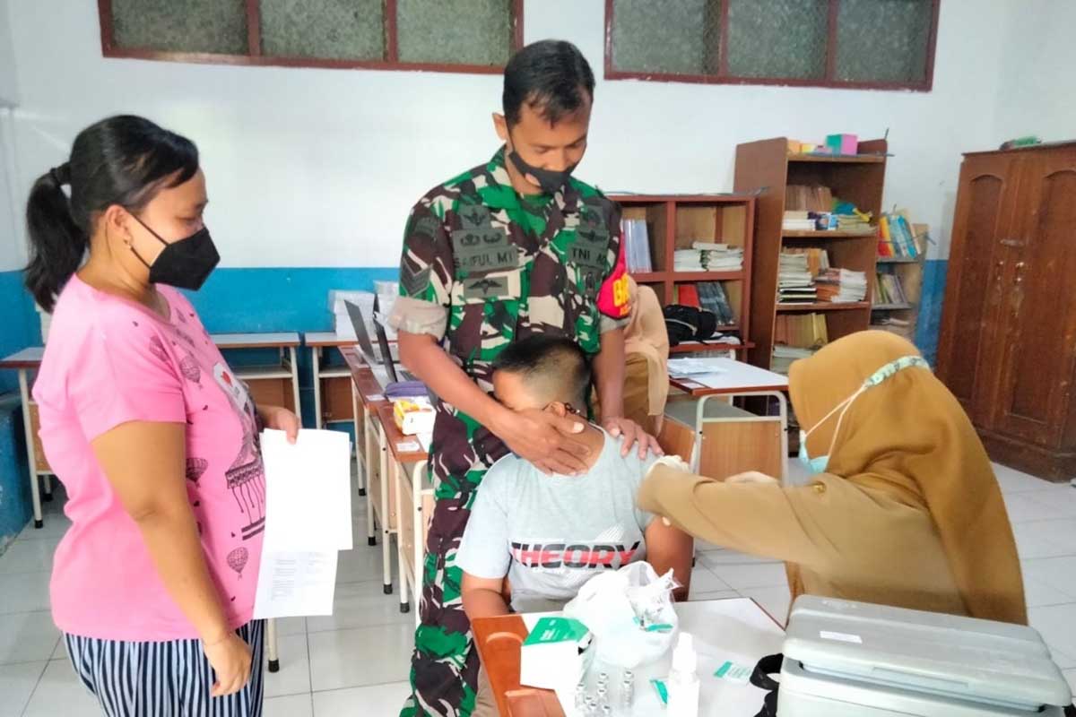 Anggota TNI menenangkan anak yang takut jarum suntik. (ist) - TNI-Polri Dukung Pemkot Malang Kebut Vaksinasi Anak 6-11 Tahun
