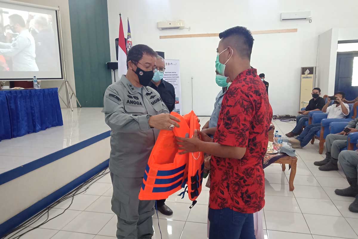 Deputi Informasi Hukum dan Kerjasama (Inhuker) Bakamla RI, Laksda Drs. I Putu Angga S saat menyerahkan baju pelampung kepada anggota Rapala Bakamla RI sebagai tanda selesainya kegiatan pelatihan - Deputi Inhuker Bakamla RI Menutup Kegiatan Pelatihan Lanjutan Peningkatan Kompetisi Rapala