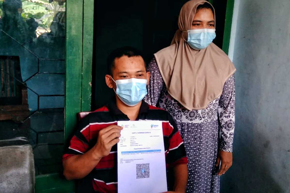 Joko Santoso menunjukkan kartu vaksin. (ist) - Diduga Efek Vaksin, Warga Kedungkandang Alami Gangguan Penglihatan