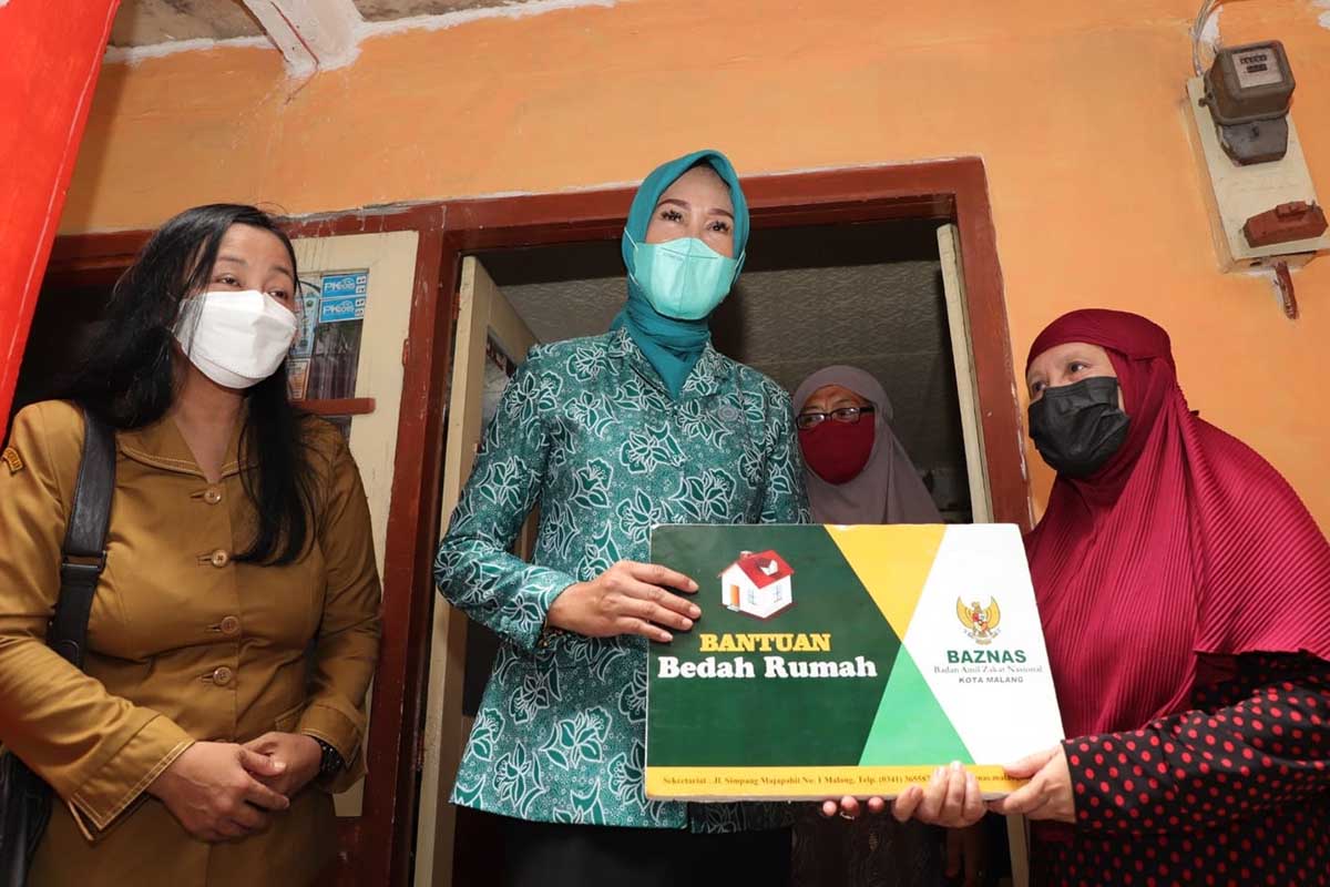 Ketua TP PKK Kota Malang, Widayati Sutiaji memberikan simbolis apresiasi bedah rumah. (jaz) - Baznas dan TP PKK Kota Malang Serahkan Bantuan Bedah Rumah
