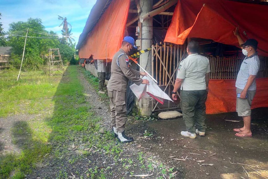 Petugas Satpol-PP Banyuwangi saat membuka segel penutupan peternakan unggas milik Susilo warga Dusun Curahjati, RT 01 RW 02, Desa Grajagan, Kecamatan Purwoharjo, Kamis (2/12/2021) (Foto: Hafid Bahtiar) - Segel Penutupan peternakan Dibuka, Pemilik Tetap Adukan Oknum Satpol PP dan Oknum Kades Ke Penegak Hukum