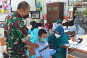 Petugas menyemangati anak SD yang sedang divaksin. (ist) - Jelang Akhir Tahun, Pemkot Geber Vaksinasi Anak SD