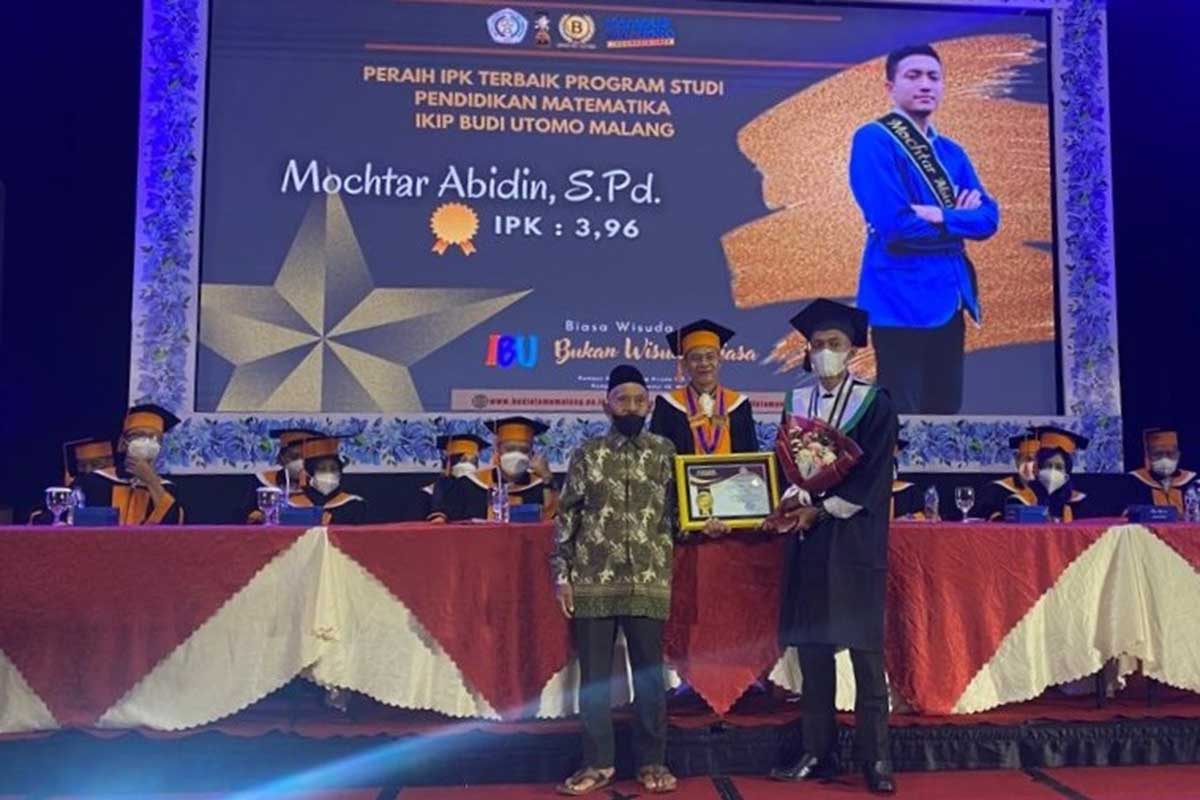 Rektor IBU Malang, Dr H Nurcholis Sunuyeko, MSi menyematkan pita toga pada salah satu wisudawan terbaik IBU Malang. (ist) - 'Bukan Wisuda Biasa' Antarkan 493 Mahasiswa IBU Kembangkan Kreativitas di Luar Kampus