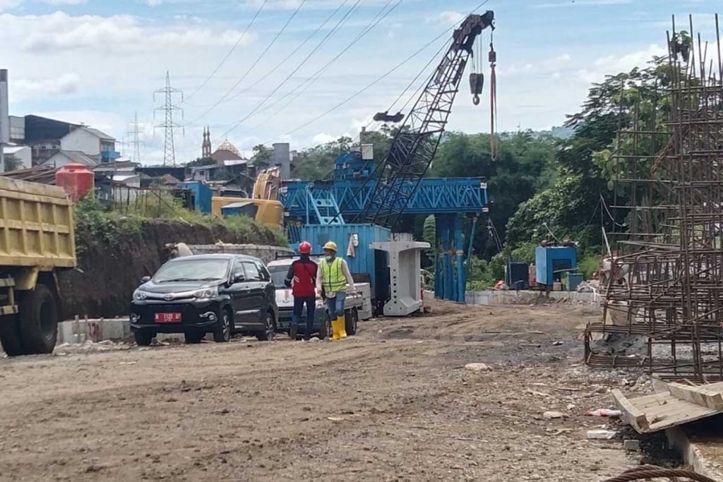 Tampak beberapa pekerja lalu lalang menyelesaikan proses pengerjaan. (jaz) - Pengerjaan Molor, Kontraktror Jembatan Tlogomas Didenda Rp43 Juta per Hari