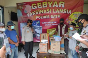 Penyerahan doorprize pada lansia pemenang undian. (ist) - Dongkrak Vaksinasi Lansia, Polres Batu Rangsang Bagi-bagi Doorprize