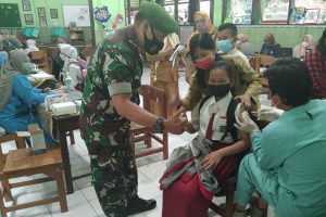 Petugas memotivasi salah satu siswi saat vaksin. (ist) - Sejumlah SD Jadi Sasaran Vaksinasi Anak di Kota Malang