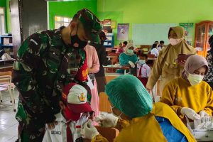 Petugas mendampingi dan menyemangati siswa SD yang divaksin. (ist) - Vaksinasi Anak Digeber pada Dua SDN di Kecamatan Blimbing