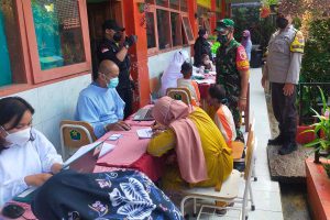 Salah satu ortu ikut mendampingi anaknya saat akan divaksin. (ist) - 153 Siswa SDN Madyopuro 06 Ikuti Vaksinasi Anak