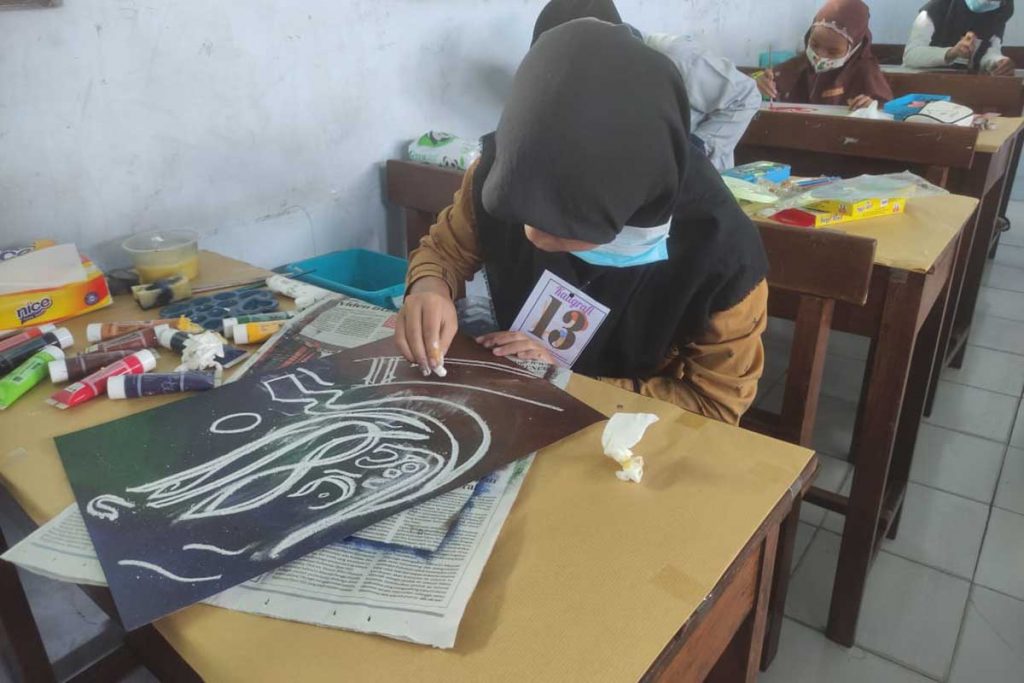 Salah satu peserta Kaligrafi serius menyelesaikan karyanya. (rhd) - Ribuan Siswa SD/MI Meriahkan Try Out Akbar & AKSI XI MTs Almaarif 01 Singosari