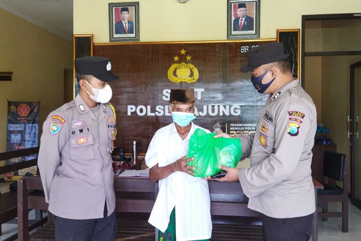 Kanit Binmas Polsek Ajung, Aiptu Edi Purnama SH, memberikan sembako pada lansia yang sudah mengikuti vaksinasi. (yas) - Masifkan Vaksinasi Lansia, Polsek Ajung Bagi Sembako