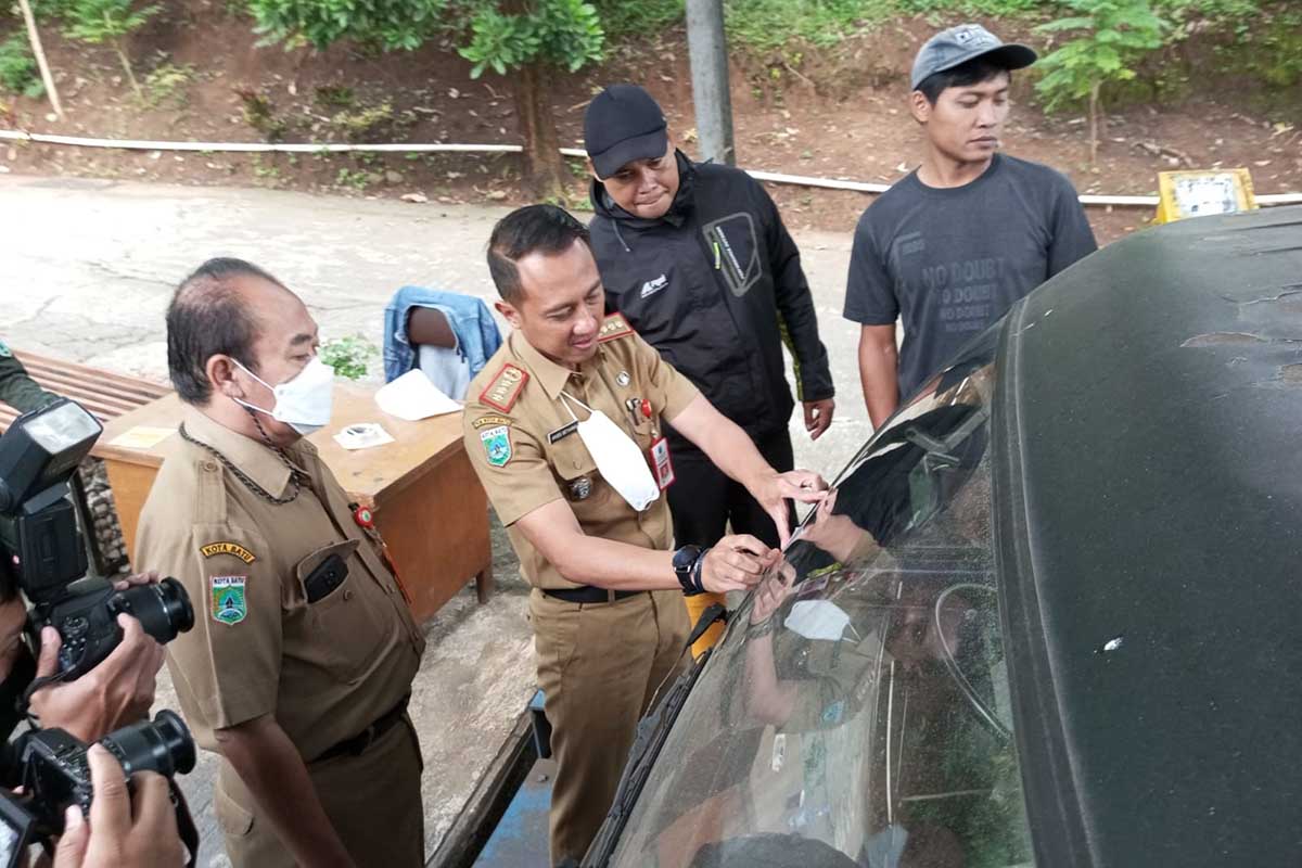 Kepala DLH Batu memasang stiker khusus ke kendaraan pembawa sampah. (ws3) - Kendaraan Berstiker Khusus, Boleh Buang Sampah di TPA Tlekung Batu