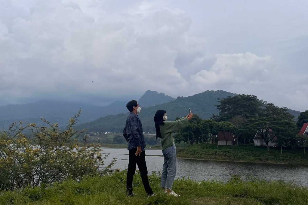 Pengunjung wisata nikmati pemandangan dengan tetap menjaga jarak dan pakai masker. (ws5) - Waduk Selorejo Sepi, Sejumlah Wisatawan Wajib Taati Prokes, Begini Aturannya