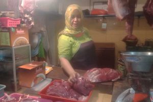 Penjual daging sapi, Ulfa, saat menimbang daging. (ws4) - Harga Daging Sapi Naik Rp125 Ribu/Kilogram, Pedagang Pasrah Menunggu Pembeli