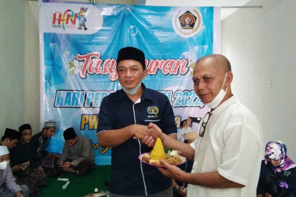 Penyerahan pemotongan tumpeng kepada salah perwakilan mantan wartawan senior. (ist) - Tasyakuran HPN ke-76 2022, PWI Malang Raya Disambangi Para Mantan Wartawan Senior